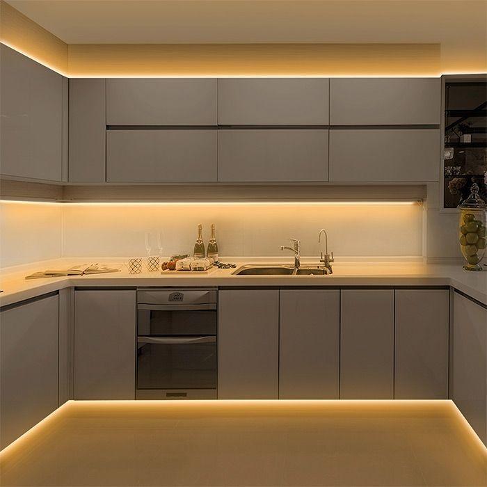 Modern kitchen interior with sleek cabinets and warm ambient lighting under countertops and cabinets.