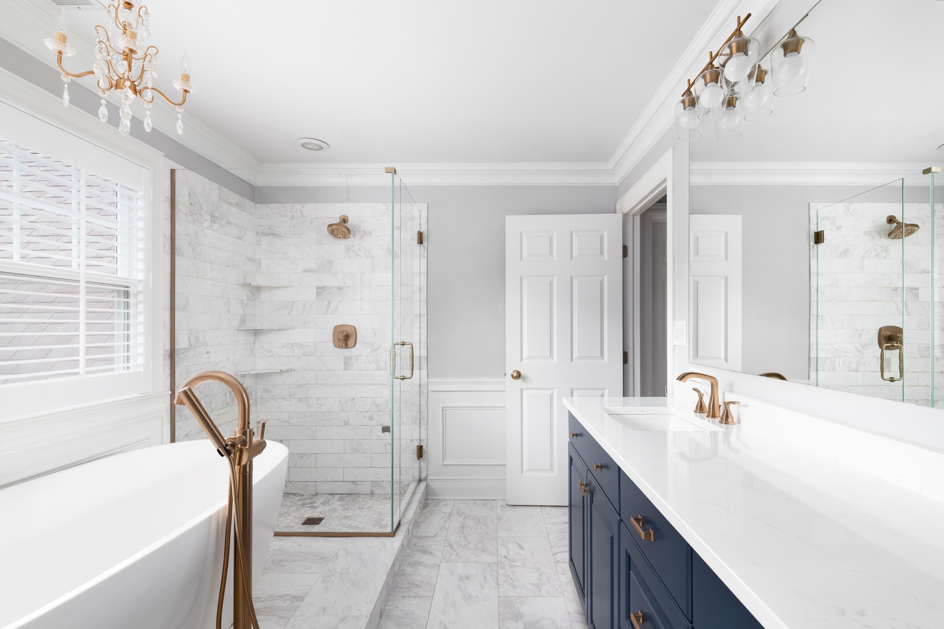 Luxurious renovated bathroom featuring a modern vanity, elegant tile work, a spacious glass shower, and ambient lighting, designed by NobleStar Construction